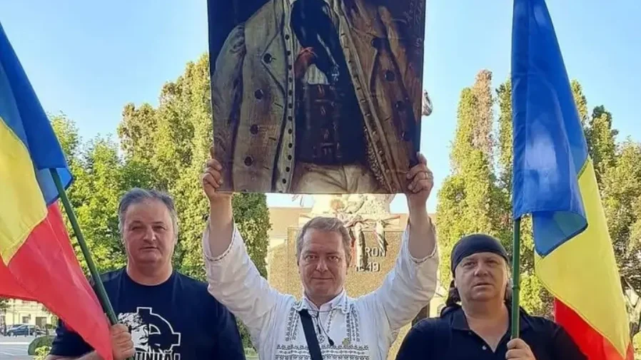 A fényképen a budapesti gyűlést szervező Mihai Tirnoveanu a magyarokat gyilkoló Avram Iancu képével.